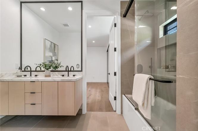 Remodeled guest bathroom with tiled shower and custom cabinetry at the Gloucester Lane home