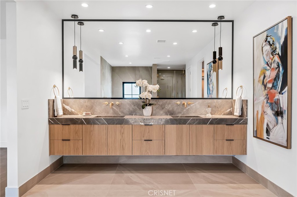 Custom vanity with stone countertop and framed mirror in the Gloucester Lane home in Thousand Oaks