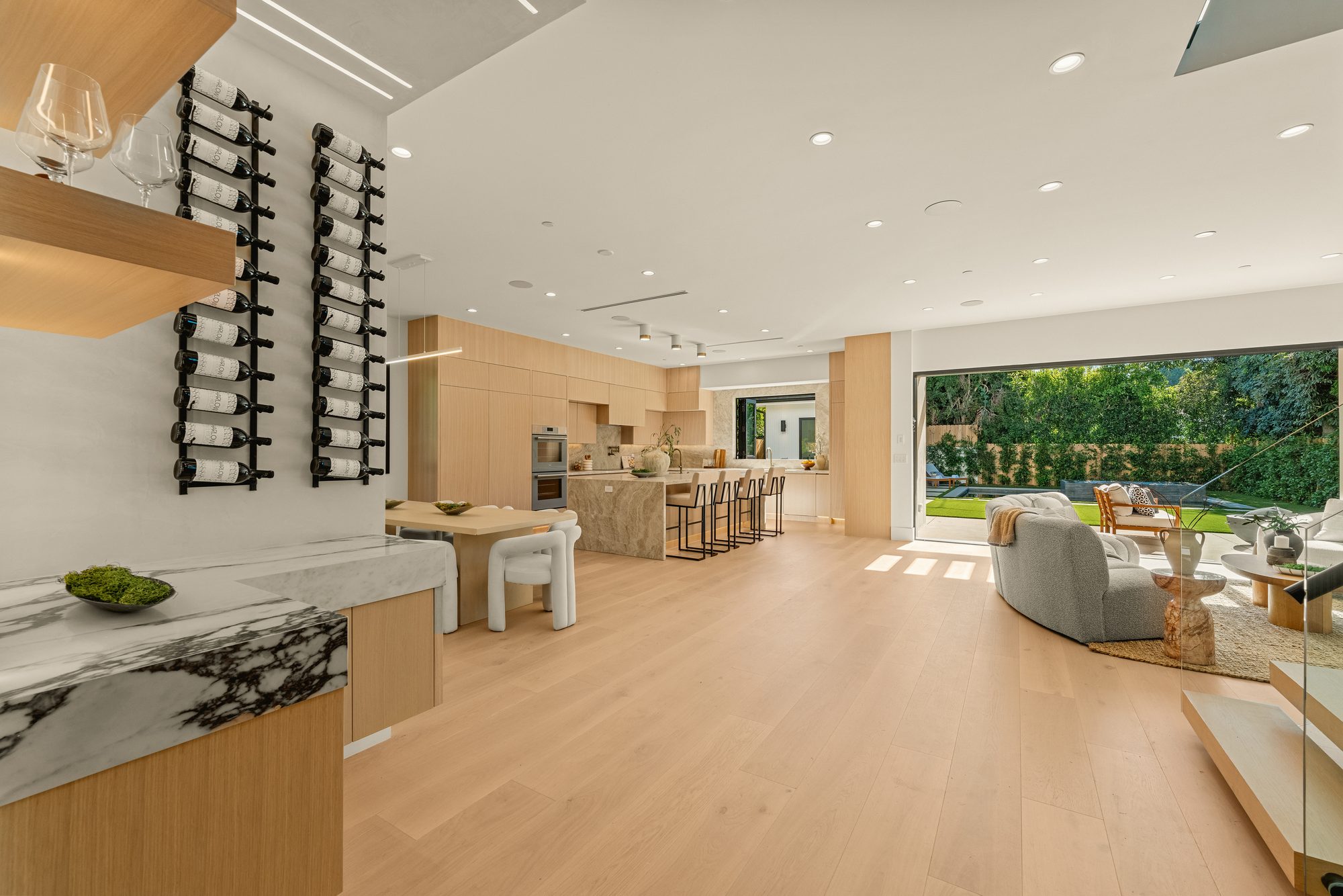 Great room combining kitchen, dining and living areas under one open volume with wide-plank oak floors
