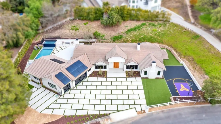 Aerial view of 792 Gloucester Lane in Thousand Oaks — a single-story tile-roof home on a large lot with a pool, paver driveway and private sport court